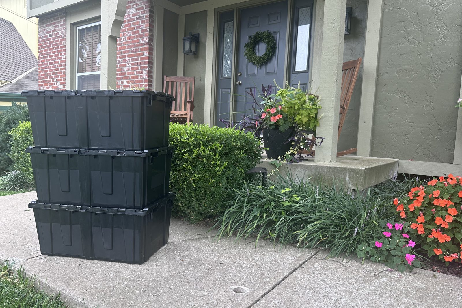 Three JoCo Bin Co moving bins stacked on the front walk of an Overland Park home